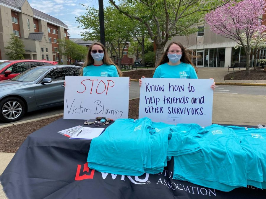 Destinee Daugherty (Left) and Ashlynn Evans (Right) man the SGA booth at Tuesdays event holding supportive posters. Other signs included phrases said to victims of sexual assault by abusers, such as one stating its not rape if were dating, now stop crying, youre ruining it.
