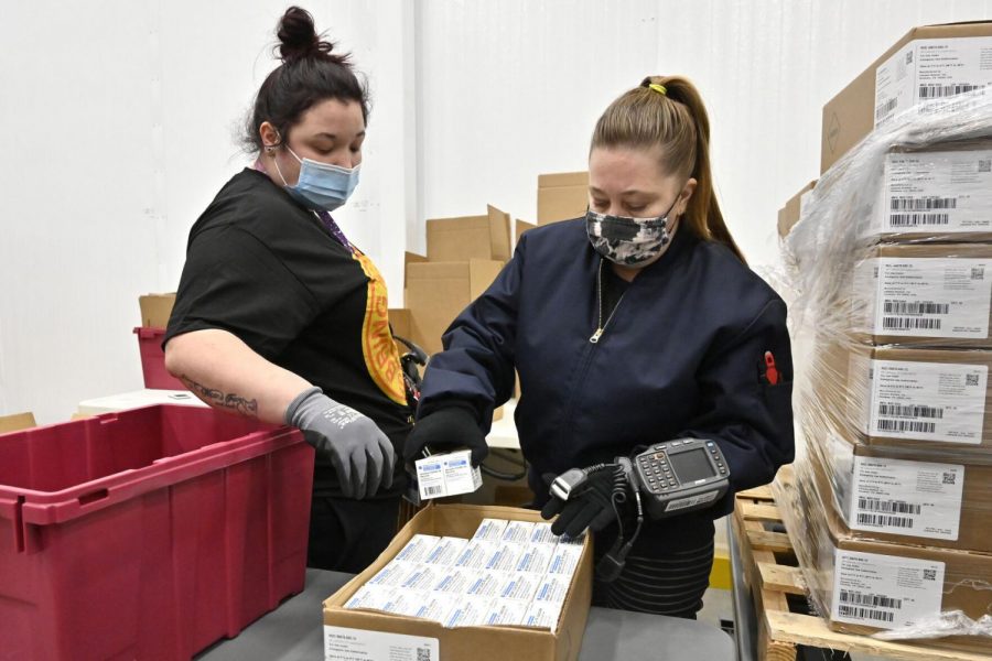 Employees with the McKesson Corporation scan a box of the Johnson & Johnson COVID-19 vaccine while filling an order at their shipping facility in Shepherdsville, Ky., Monday, March 1, 2021.