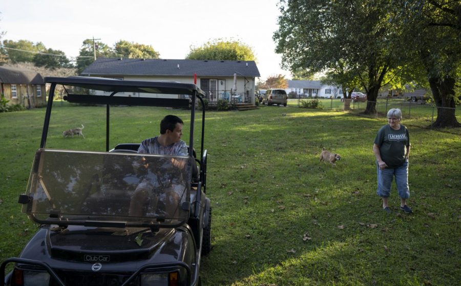 Junior Morgan slowly backs up his golf cart from the shed as his mom Cathy Morgan watches in their yard in Bowling Green on Oct. 21, 2021. He only drives it in the yard, cautiously switching between the gas and brake. Cathy drives the golf cart 5 miles on the backroads to take Junior to Chaney’s Dairy barn to get food and ice cream occasionally during the week.