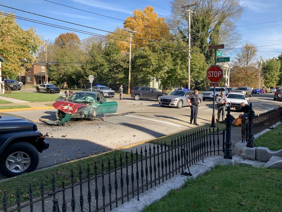 The driver of the green sedan is restrained on the sidewalk (right) after State police removed him from the crashed vehicle Tuesday morning.