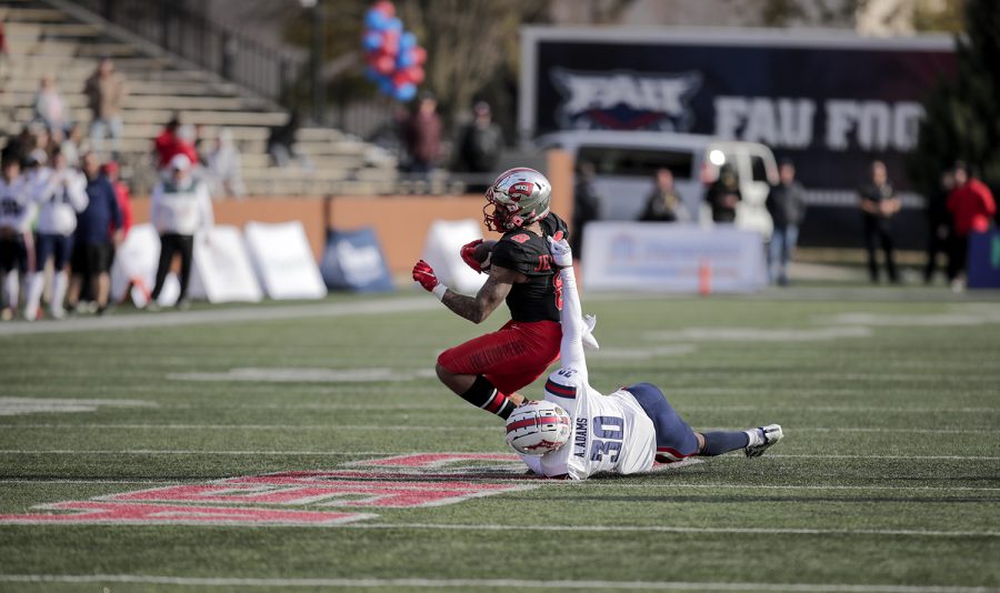 Hilltoppers’ junior wide receiver Jerreth Sterns (8) is pulled to the ground by FAU Owls’ Armani-Eli Adams (30).