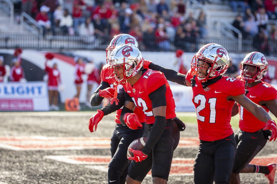 WKU Hilltoppers sophomore defensive backs Kahlef Hailassie (12) and Beanie Bishop (21) celebrate after returning it to the house during the MTSU game.