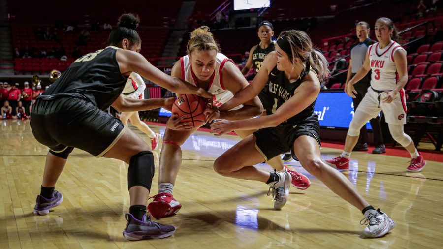 WKU+Lady+Toppers%E2%80%99+redshirt+freshman+forward+Gabby+Mcbride+%2842%29+resists+attempts+to+strip+the+ball+Virginia+State+University+Yellow+Jackets+freshman+forward+Emyah+Fortenberry+%2833%29%2C+and+senior+guard+Payton+Shears+%2814%29+during+an+exhibition+match+Wednesday+evening%2C+Nov.+3+of+2021+in+Diddle+Arena.+WKU+won+the+match+112-72.