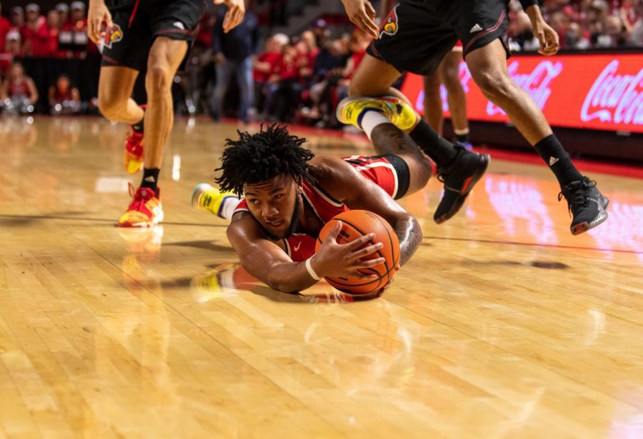 WKU guard Dayvion McKnight (20) dives for the ball after it was dropped during the WKU v University of Louisville basketball game at Diddle Arena on Dec. 18, 2021.