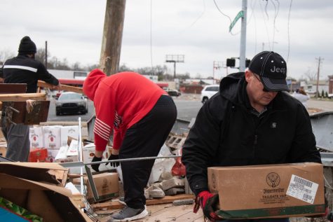 Volunteers help clear out merchandise from WK Liquors after it was hit by an EF-3 tornado Saturday Dec. 11, 2021.