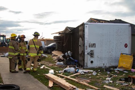 Members of the Bowling Green Fire Department discuss clean up efforts of a tractor trailer that was tipped over during the tornadoes on Saturday Dec. 11, 2021. 