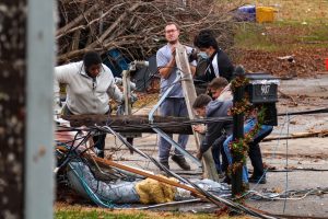 A group of community members work together to remove debris after tornadoes and severe weather swept through Bowling Green, KY on Dec. 11.