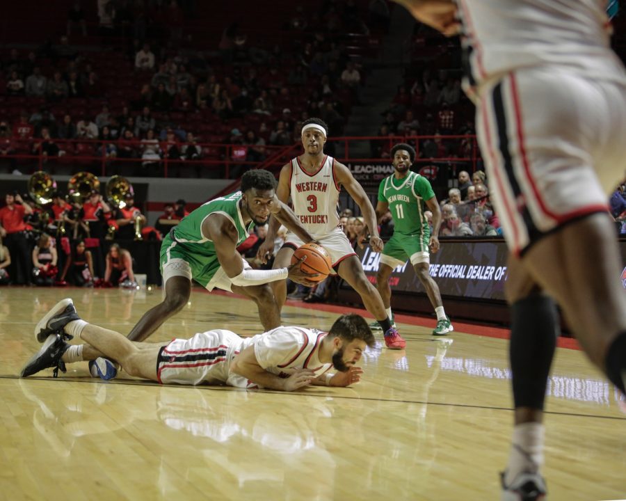 North Texas Mean Green’s fifth-year forward Thomas Bell (4) dodges an attempted steal by WKU Hilltoppers’ graduate student guard Camron Justice (55) on the afternoon of Saturday, Jan. 15 2022, in Diddle Arena. North Texas won the match 65-60.