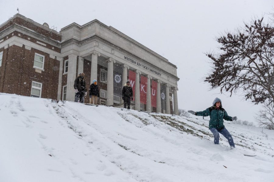 Eva Engelland-Spohn (right) slides down the hill at Van Meter Hall after several inches of snowfall on Jan. 6, 2021.