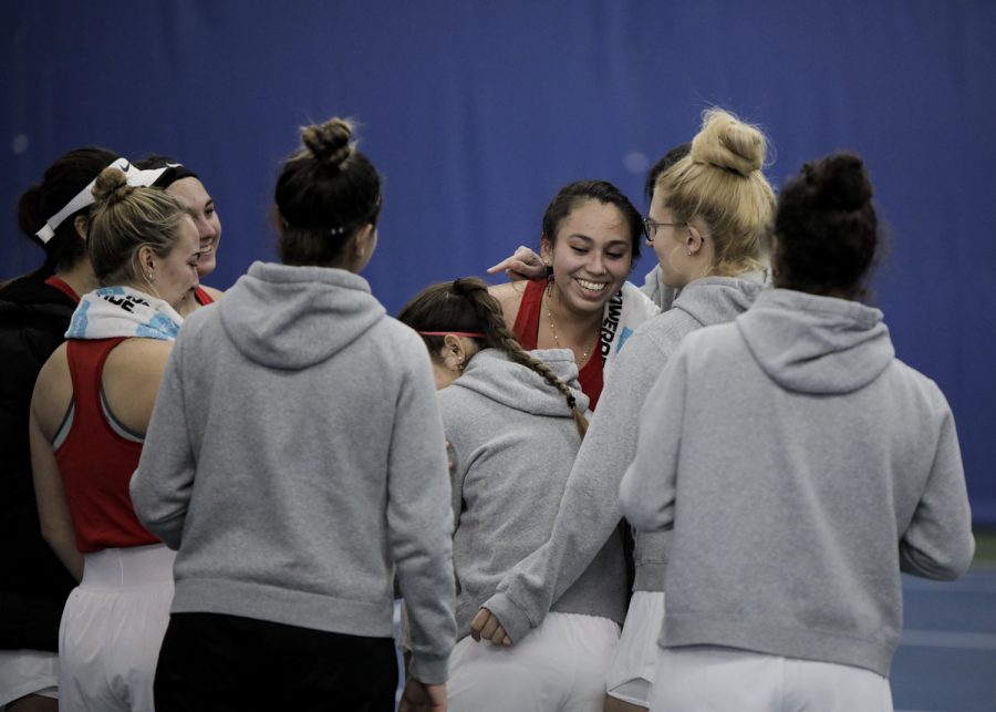 Western Kentucky University Hilltoppers women’s tennis team celebrate with redshirt sophomore Paola Cortez (center) after she won the last set in their match against Indiana University–Purdue University Indianapolis Jaguars on the afternoon of Sunday, Feb. 6, 2022, at Michael O. Buchanon Park’s tennis facility. WKU won the match 7-0.