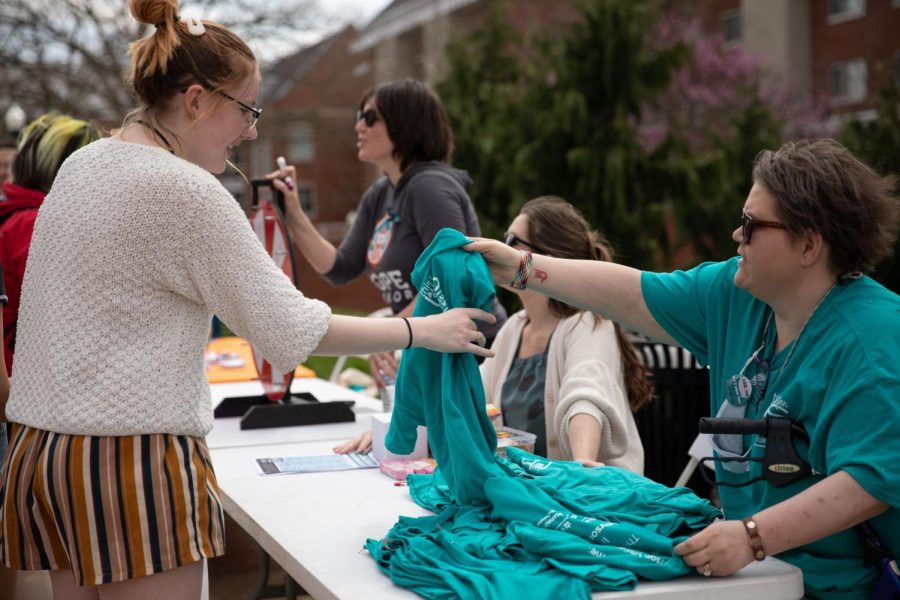 Elizabeth Madariaga (right) Sexual Assault Services Coordinator at the WKU Counseling Center hands out a free t-shirt to a student as her, Melanie Evans (middle) Coordinator for WKU Student Conduct, and Maja O’Connell of Hope Harbor table on campus on Wednesday, March 30th for sexual assault awareness on campus.