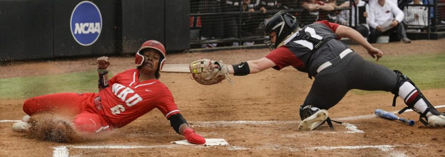 Hilltoppers Softball’s senior outfielder Taylor Davis (6) slides  home avoiding the tag of the University of Arkansas Softball’s catcher to put a run on the board during their matchup on March 21st at the WKU Softball Complex.