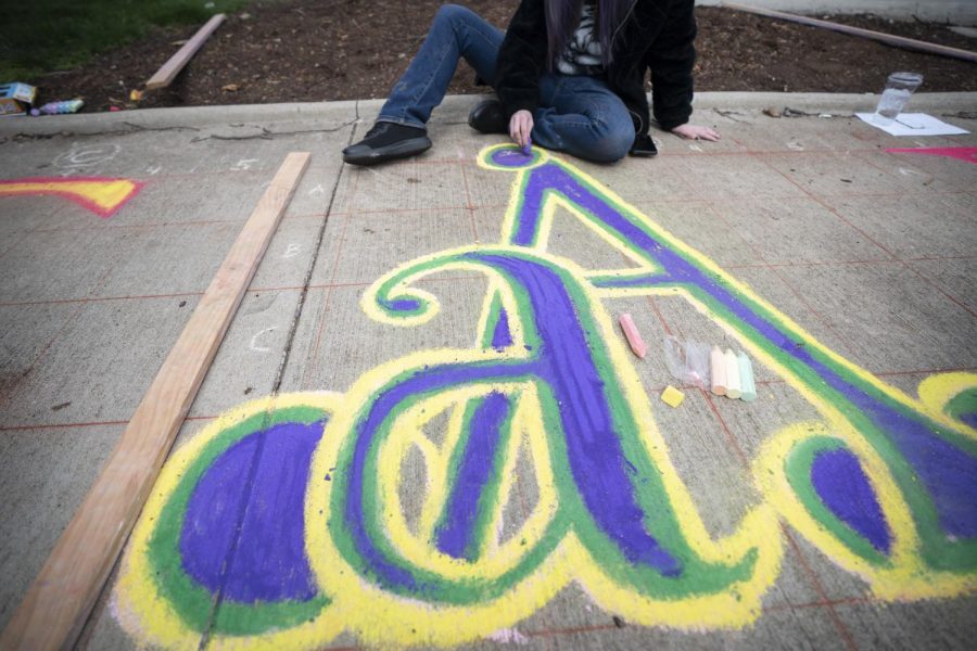 A PCAL student uses a grid to render artistic letters spelling out PCAL on the sidewalk of Fountain Square Park as part of the PCAL Spring Forward Festival on Saturday, April 9. 