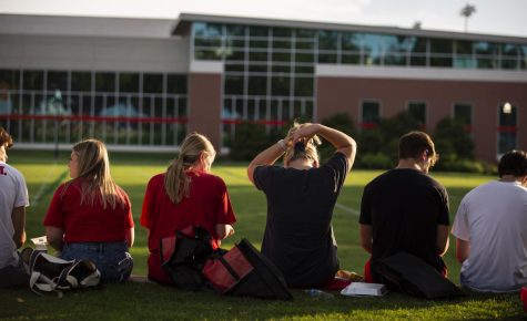 WKU students cool off in the shade while they eat during Topperfest on south lawn on WKU Campus in Bowling Green, Ky. on Friday, Aug. 19.