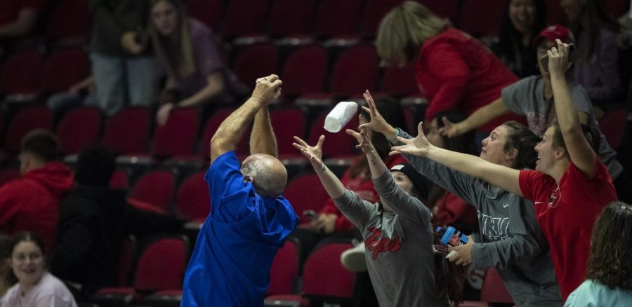 Fans at the WKU volleyball match with FIU reach for a t-shirt thrown by the cheer team during an intermission in E.A. Diddle Arena on WKU Campus in Bowling Green, Ky. on Friday, Sept. 30, 2022. WKU won 3-0.