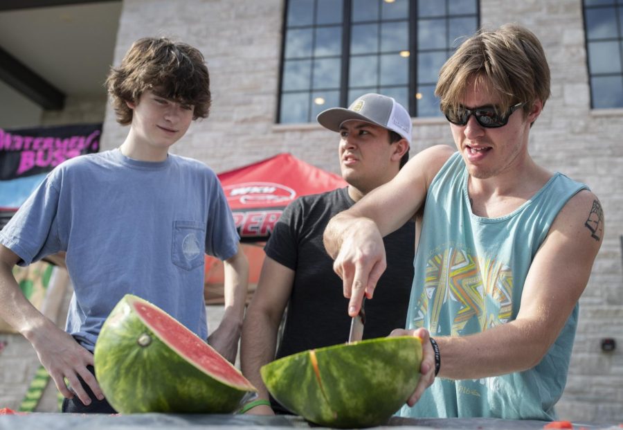 Caleb Spain (right) a senior in business administration cuts a watermelon for a watermelon eating contest during watermelon bust at the Lambda Chi Alpha chapter house on WKU Campus in Bowling Green, Ky. on Friday, Sept. 9, 2022. 
