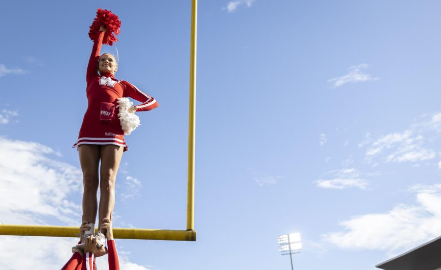 A member of the WKU cheer team is lifted by their teammates on Feix Field ahead of the WKU Homecoming game against University of North Texas on Saturday, Oct. 29, 2022. WKU lost 40-13.