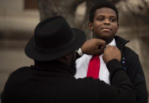 Bryson Bailey, a mentor at the Jonesville Academy assists Adrian Carter, 9, with his shirt collar ahead of the Dr. Martin Luther King Jr. holiday celebration march through downtown Bowling Green, Ky. to State Street Baptist Church on Monday, Jan. 16, 2023. 