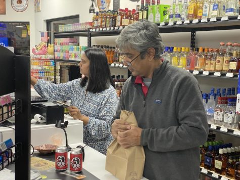 Manojkumar Patel, owner of WK Liquors, bags a purchase for a customer on Thursday, Jan. 19 at the reopening of the store in Bowling Green, Ky.