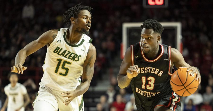 Sixth+year+guard+Emmanuel+Akot+%2813%29+drives+down+the+court+under+heavy+defense+by+UAB%E2%80%99s+senior+forward+Ty+Brewer+%2815%29+in+E.A.+Diddle+Arena+on+Saturday%2C+Feb.+25%2C+2023.+WKU+lost+72-60.