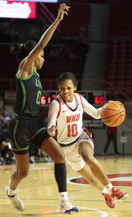 Freshman guard Acacia Hayes (10) on a drive under heavy defense during the matchup with UNT in E.A. Diddle Arena on March 4, 2023. WKU won 76-67.