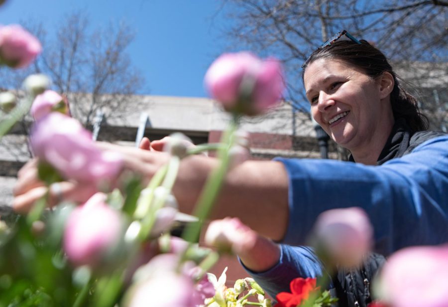 Michelle Wheeler, 49, owner of River Bend Blooms, picks out a flower for a customer on Wednesday, March 29, 2023 during the Market on the Avenue event held at Centennial Plaza on the WKU campus in Bowling Green, Ky.