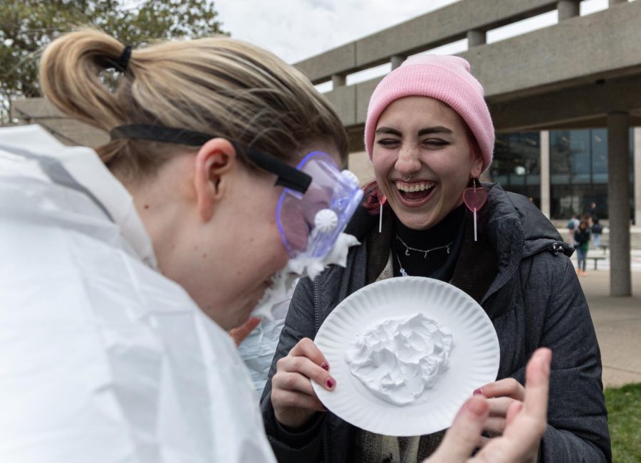 WKU assistant professor of psychological sciences Katrina Burch (left) laughs after being pied in the face by psychological sciences student ambassador Grace Salloum (right) during the Pi(e) a Professor fundraiser on Wednesday, March 8, 2023 at the lawn outside of FAC on campus in Bowling Green, Ky. 