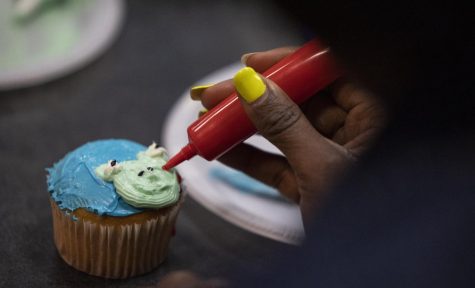 Black Art Nouveau creative director Shylin Jordan, a sophomore theater major creates a frog on a cupcake during the event hosted by the group in DSU on Wednesday, April 13, 2023. 