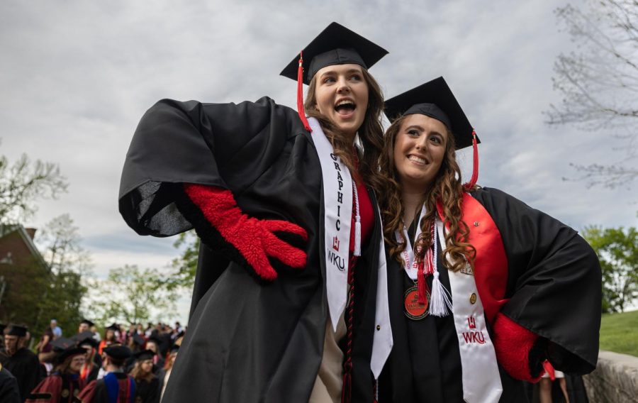 Graduating+student%28s%29+Kacy+Weinburg+%2822%2C+left%29+and+Gianna+Cecil+%2822%2C+right%29+strike+a+pose+in+their+graduation+regalia+before+Topper+Walk+down+Avenue+of+Champions+on+campus+in+Bowling+Green%2C+Ky.+Both+women+sport+red+gloves+to+commemorate+their+time+working+as+a+team+to+help+make+the+beloved+campus+mascot%2C%E2%80%9CBig+Red%2C%E2%80%9D+come+to+life.+In+order+to+embody+the+character%2C+students+must+agree+to+keep+their+identity+a+secret+until+graduation.+While+Weinburg+was+the+only+one+of+the+two+to+wear+the+suit%2C+Cecil+worked+by+her+side+acting+as+her+%E2%80%9Chandler.%E2%80%9D