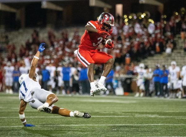 Running back Elijah Young #3 jumps over MTSU safety Tra Fluellen to score a touchdown during a game at L.T Smith Stadium in Bowling Green on Thursday, Sept. 28, 2023. WKU won 31-10.