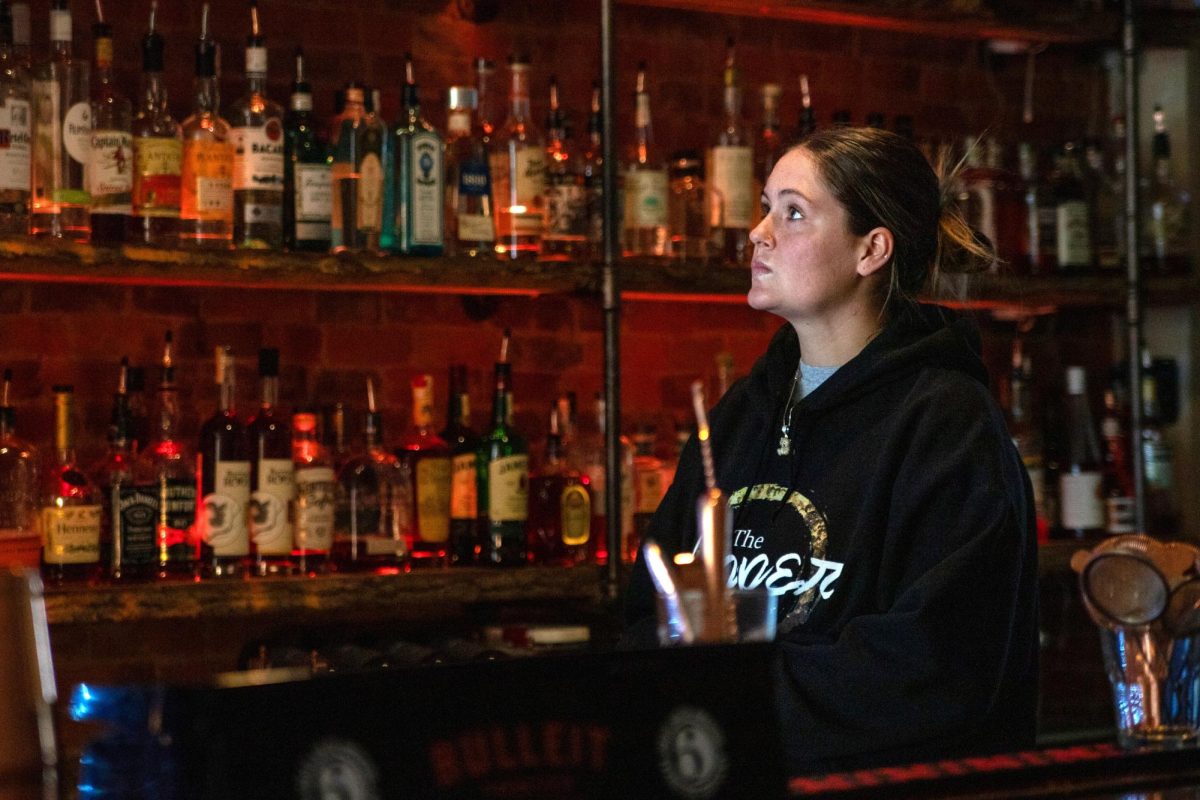 Bartender Destiny Weddle watches a college football game at The Copper Bar in Bowling Green, Ky. on Sunday, Sept. 3, 2023.
