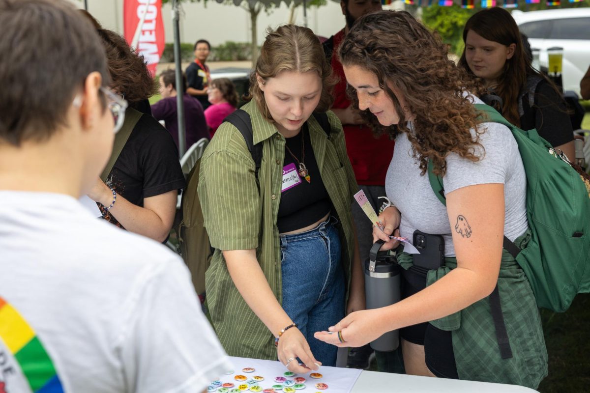 Mckenzie Phelps and Kaylee Wilson pick out pronoun pins at Pride on the Lawn at Western Kentucky University on Sept. 7, 2023.