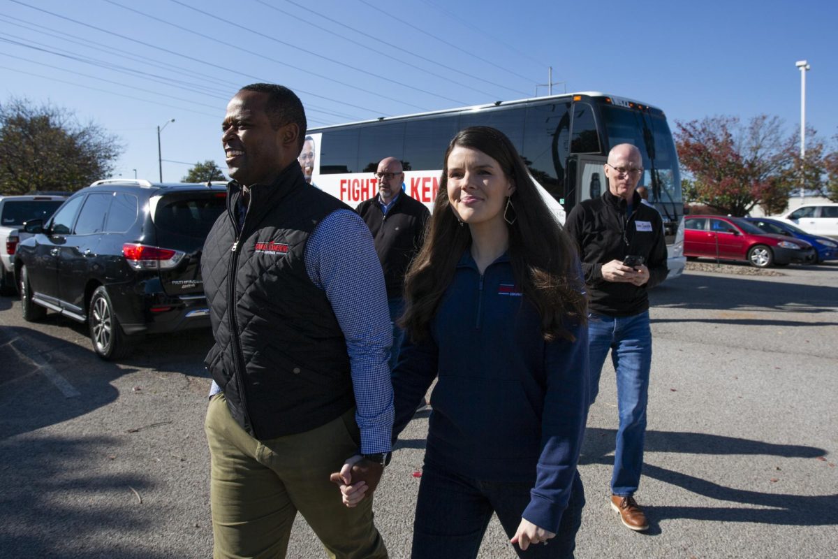Daniel Cameron and wife Makenze Evans walk from the campaign bus into Blue Cotton factory on November 1, 2023.