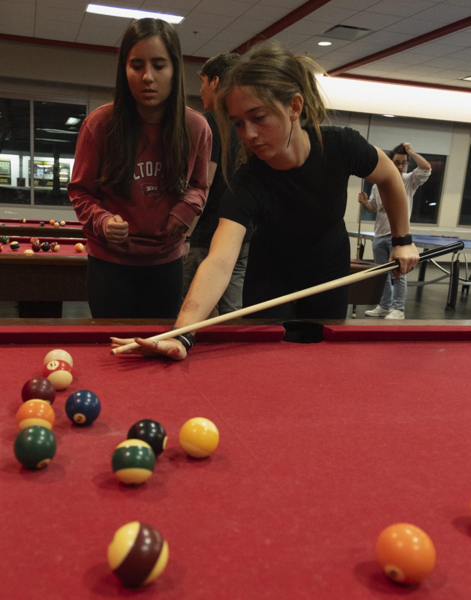 Katie Clifford, junior biology major (left), and her teammate Sabree Lefebvre, a sophomore marketing major (right), find the angle and talk strategy during the WKU Pool Club’s first meeting of the spring 2024 semester, on Monday, Jan. 22, 2024, in the recreation area in Downing Student Union.