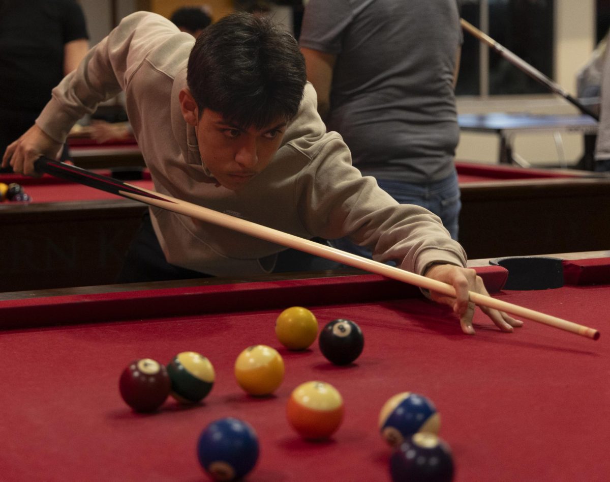 Manalo Romana, freshman exercise science major, watches the follow through on his shot during the WKU Pool Club’s first meeting of the spring 2024 semester, on Monday, Jan. 22, 2024, in the recreation area in Downing Student Union.