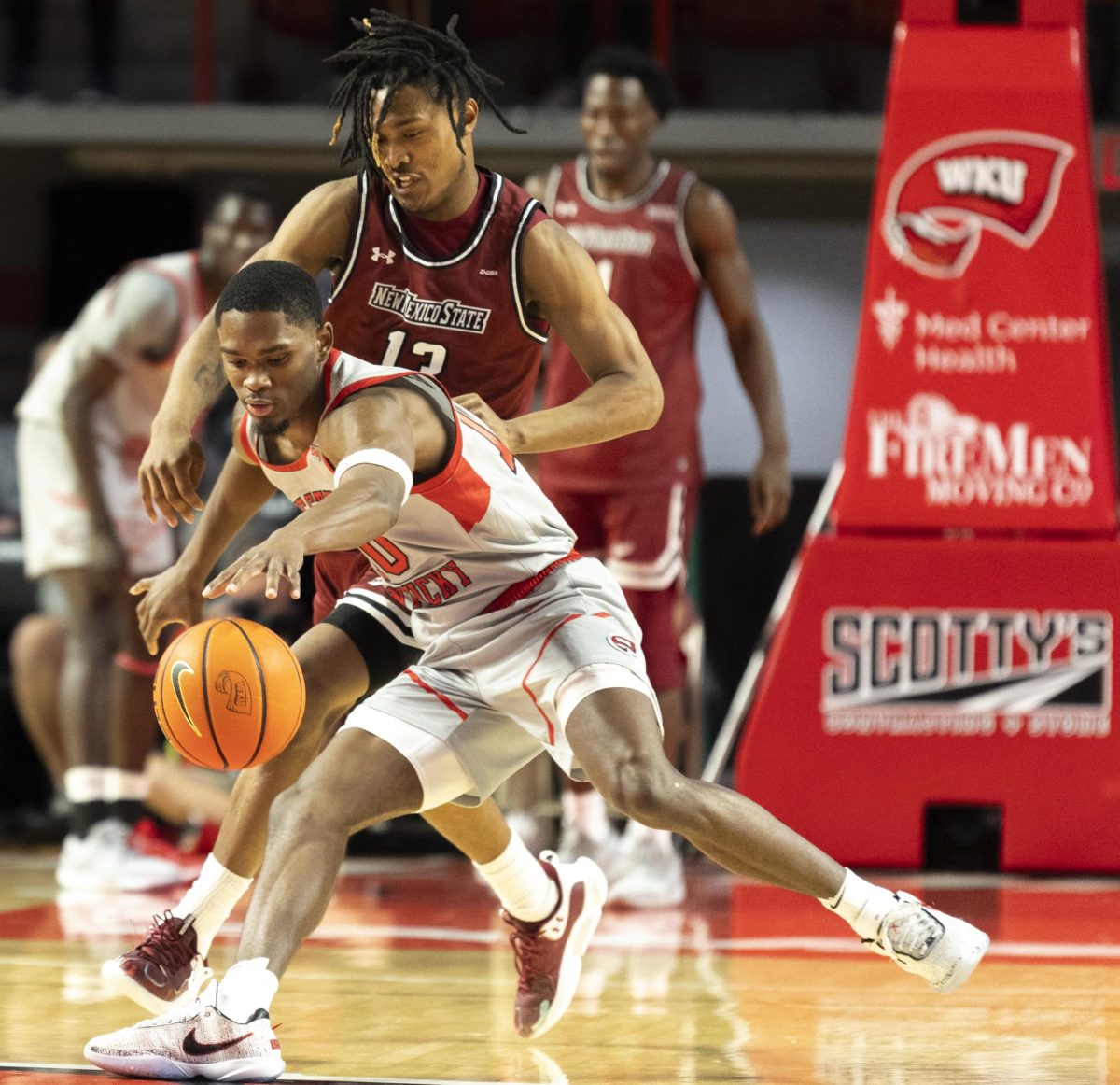 WKU guard Brandon Newman (10) reaches for a loose ball against NMSU guard Jaden Harris (13) during WKU’s Senior Night game in the Diddle Arena on Feb 17.