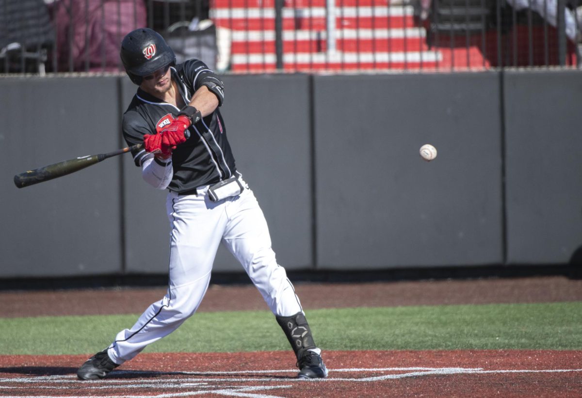 Camden Ross (8) swings at the ball during WKUs first home game series against Bradley University on Sunday, Feb. 18.