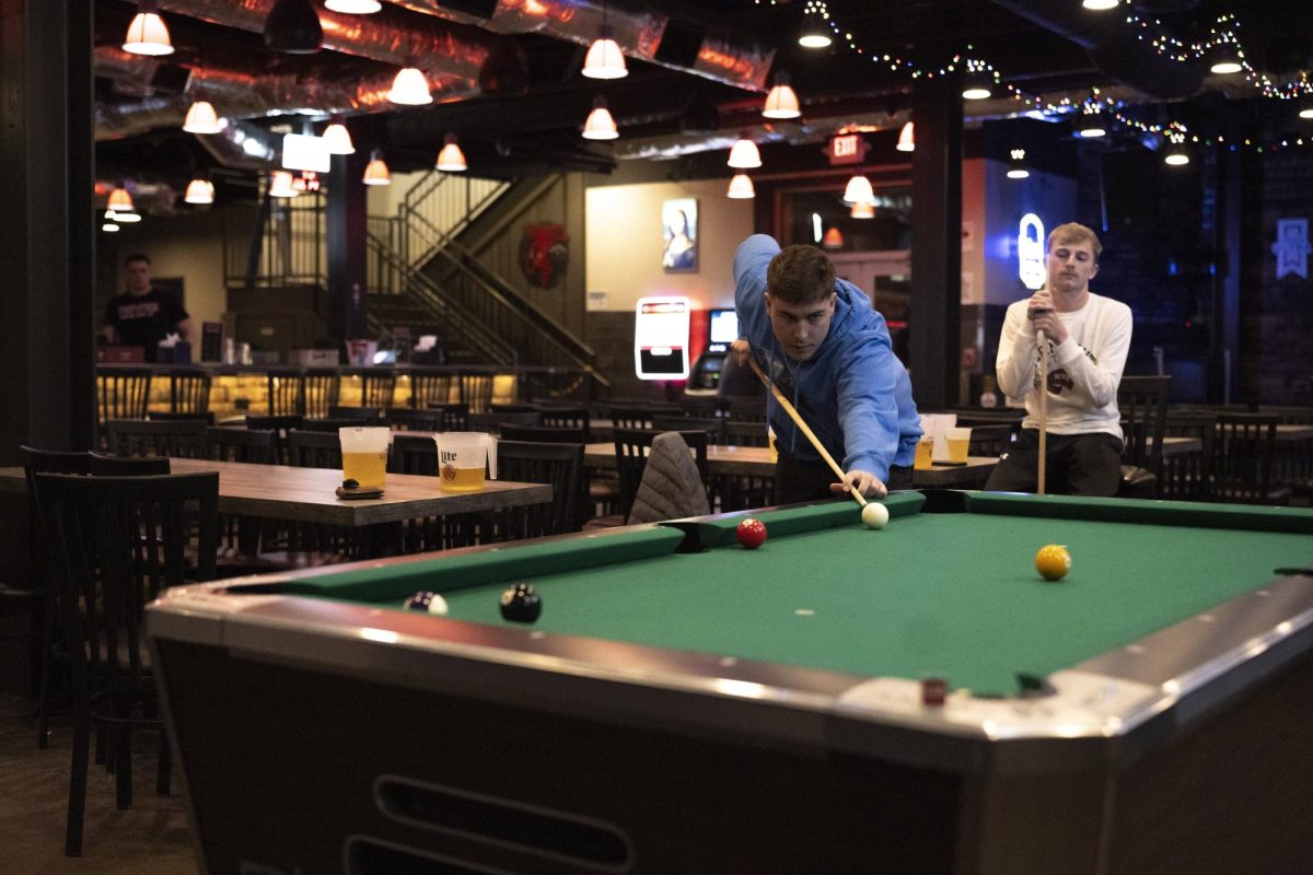 Cade Holcombe (left) and Tanner Thomas play a game of pool in Topper Social on Wednesday, Feb. 14.