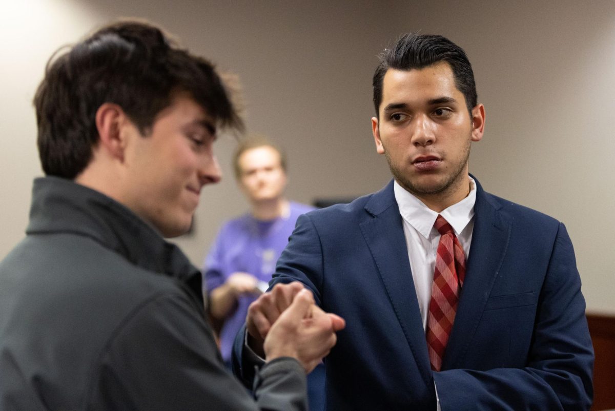 SGA Administrative Vice President Salvador León, right, shakes hands with Student Body President Sam Kurtz after León was censured during a hearing in the Downing Student Union on Wednesday, Feb. 7. 