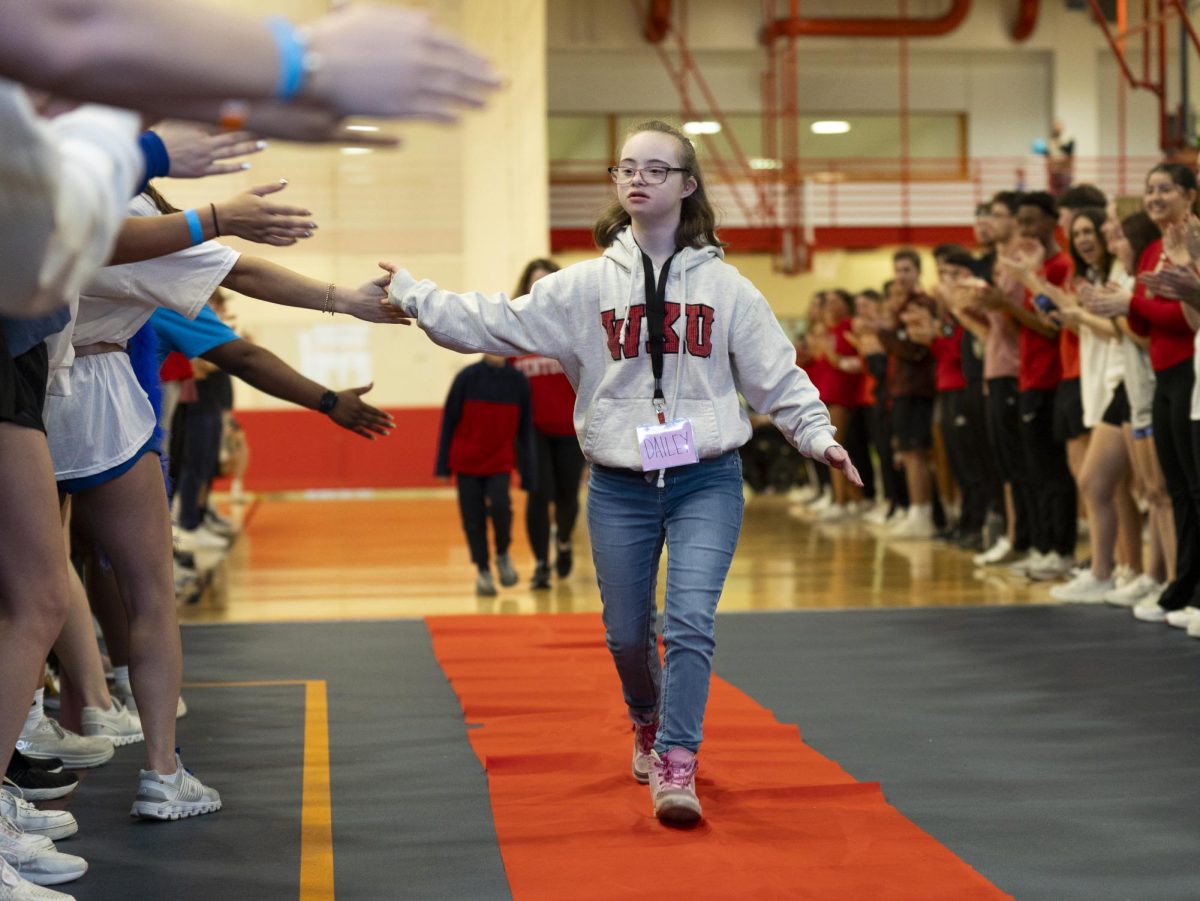 Dailey Hall, 12, walks down the aisle for her announcement at Dance Big Red in Preston Center on Friday, March 8.