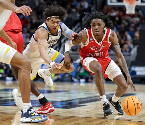 WKU guard Don McHenry (2) drives the lane against Marquette’s Stevie Mitchell (4) during the March Madness Round of 64 at the Gainbridge Field house in Indianapolis on Friday, March 22, 2024. 