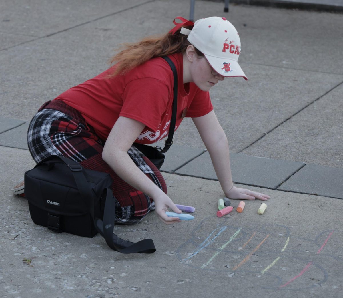 Kaylee Youngblood, a senior graphic design major decorates the concrete with chalk during the We Stand With You discussion in front of Cherry Hall on Wednesday, March 27, 2024
