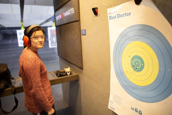 Freshman Lily Supinski stands next to her first target littered with .22 caliber and 9mm bullet holes at Sherwood’s Guns in Bowling Green, Ky. on March 9, 2024. Supinski had never shot a gun prior to the Toppers for Liberty gun range event, she wanted to familiarize herself with gun safety and impress her parents with her knowledge of firearms. 