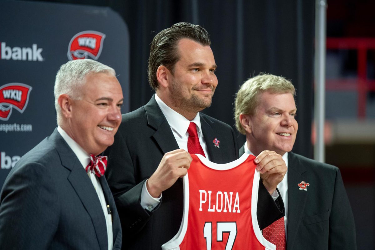 Hank Plona (middle) accepts his jersey on Wednesday, April 3, 2024. Plona, former assistant coach of Hilltopper basketball, was announced as the new head coach of the WKU basketball program.