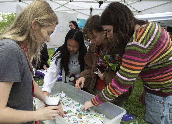 Elena Carder, junior history major (left), Jenna Wells, junior accounting and data analytics major (center left), Sophie Jerome, sophomore psychological sciences and criminology double major (center right), and Meredith Campbell, sophomore social work major (right) pick out Earth Day themed stickers at “WKU Earth Day” hosted by the WKU Office of Sustainability on Friday, April 19 in Centennial Mall.