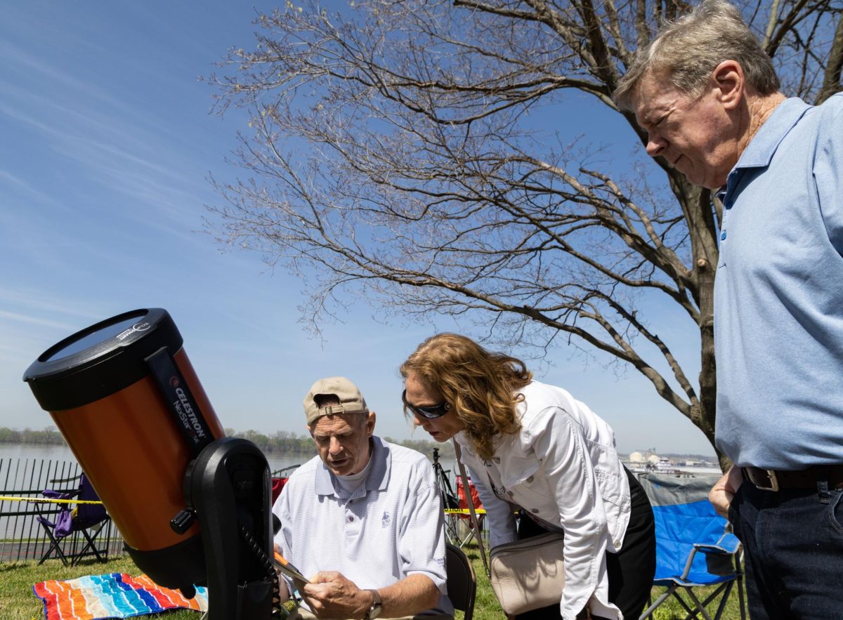 Cran Combs (left), the Owensboro Science and Industry Museum science educator, shows Sarah (middle) and David Stamps what sun spots look like while waiting for a total solar eclipse to begin at the Evansville Museum in Evansville, Ind. on Monday, April 8, 2024. “To be able to be in totality of an eclipse is a rare thing,” Combs said. “…We won’t have another eclipse like this until 2044 here in the United States and that’s going to be out west so this is probably my last one.”