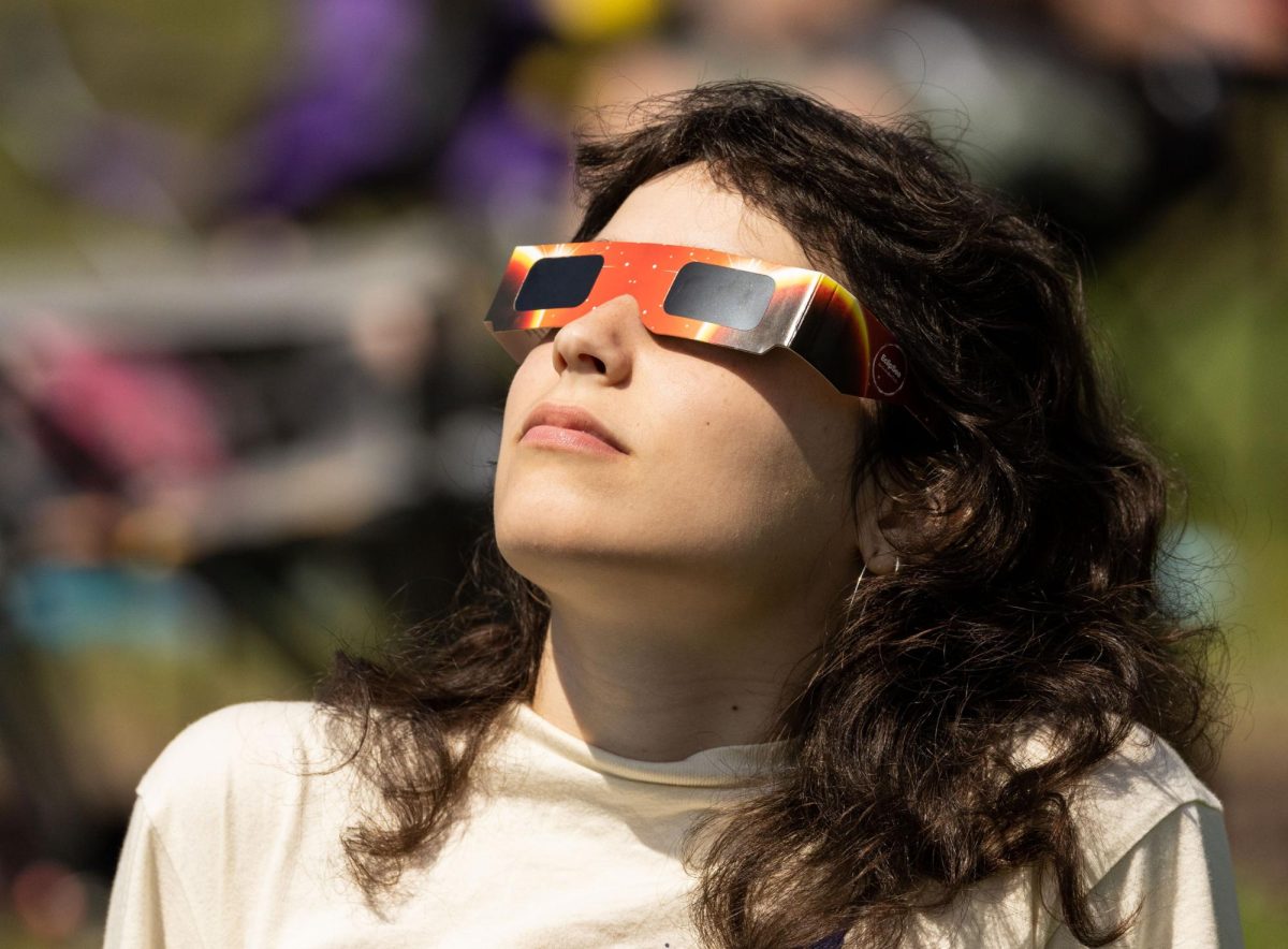 Lauren Winningham of Atlanta watches as totality approaches during a viewing of a total solar eclipse in downtown Evansville, Ind. on Monday, April 8, 2024. 