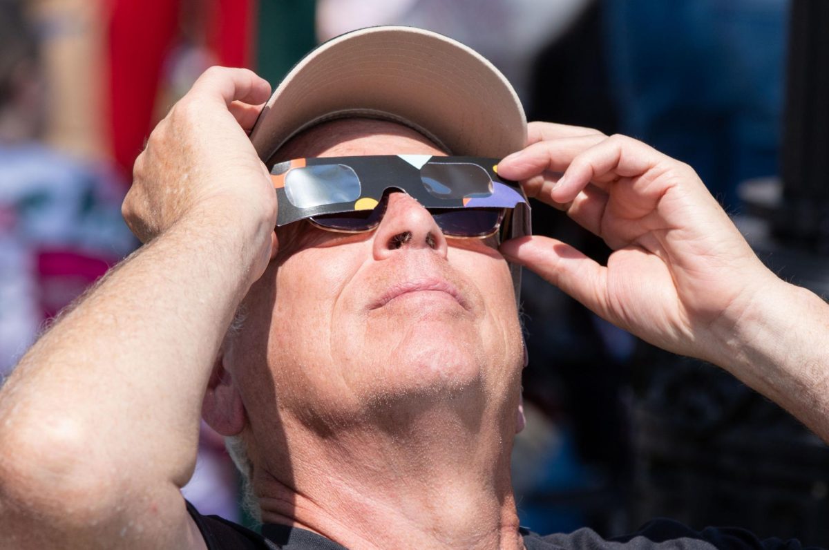 Bruce Sprague checks the status of the moon before a total solar eclipse in downtown Evansville, Ind. on Monday, April 8, 2024. 
