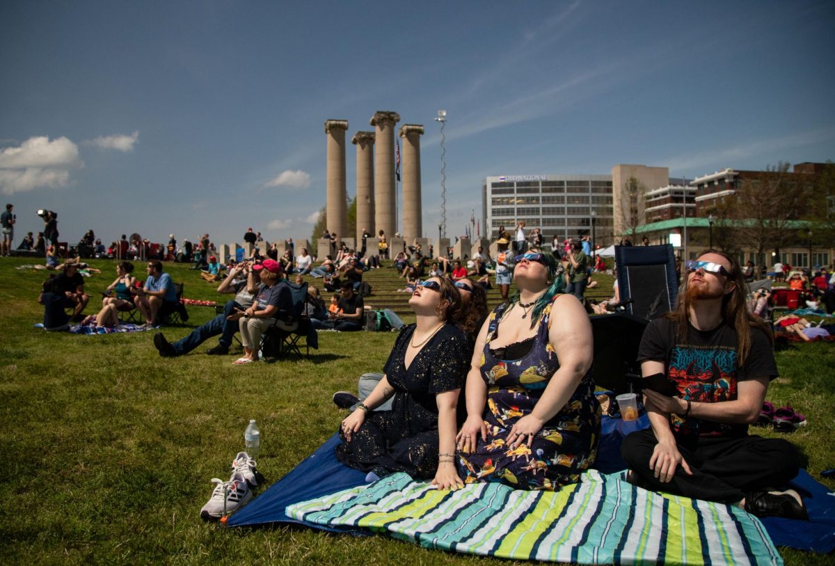 Viewers watch as a total solar eclipse begins in downtown Evansville, Ind. on Monday, April 8, 2024. 