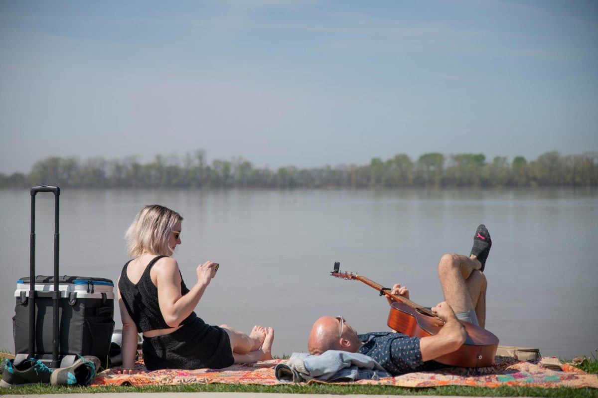 Beckett Honicker (right) and Julie Johnson pass time by playing guitar before a total solar eclipse in Evansville, Ind. on Monday, April 8, 2024. Honiker played Here comes the sun.